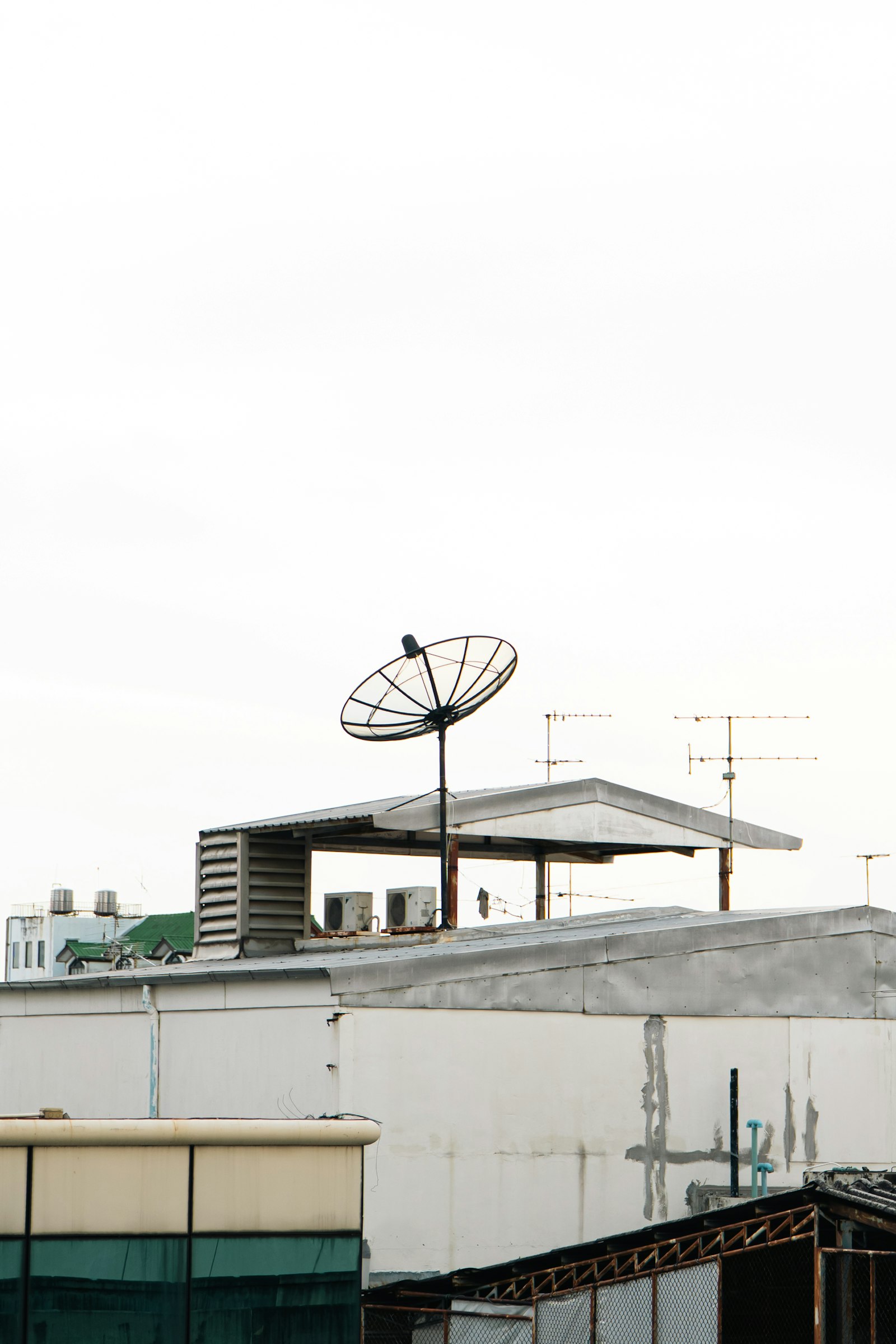 Rooftop aerial and mesh satellite dish on building